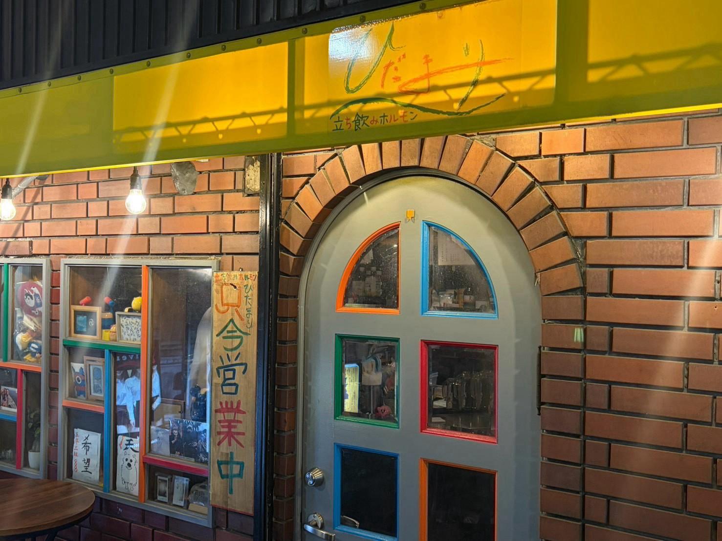 黄色い看板とアーチ扉の店先